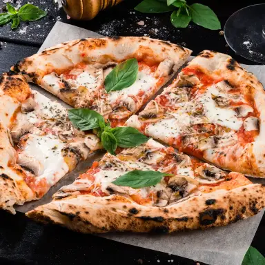 Gebackene Pizza mittig platziert auf einem Teller.