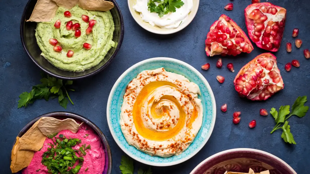 Verschiedene Arten von Hummus in ein paar Schalen verteilt.