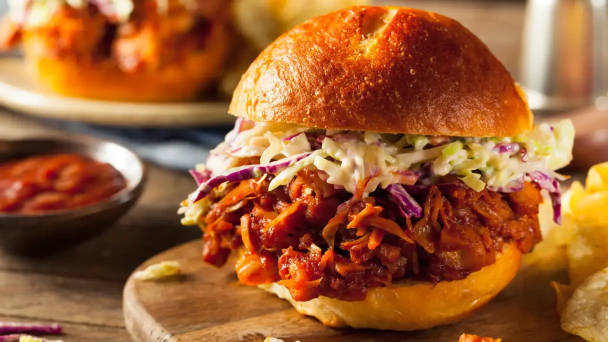Jackfruit Jackfruit Burger auf einem Teller mit Dip.