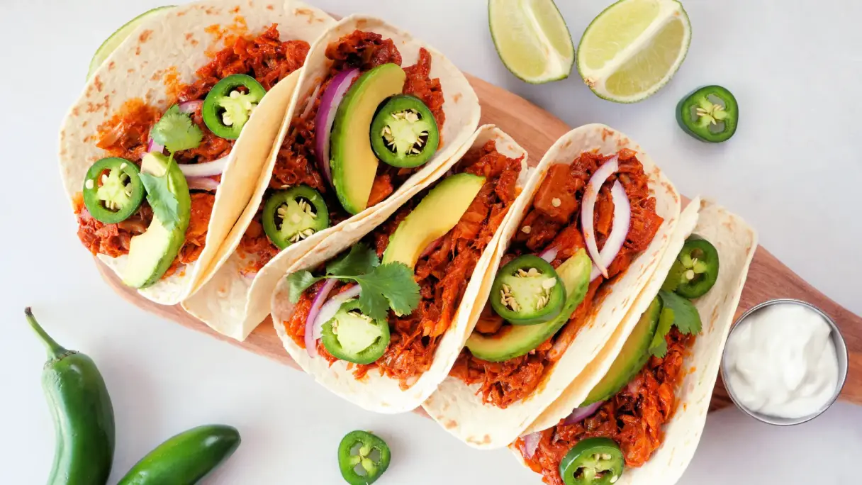 Jackfruit Jackfruit Taco auf einem Teller mit Dip.