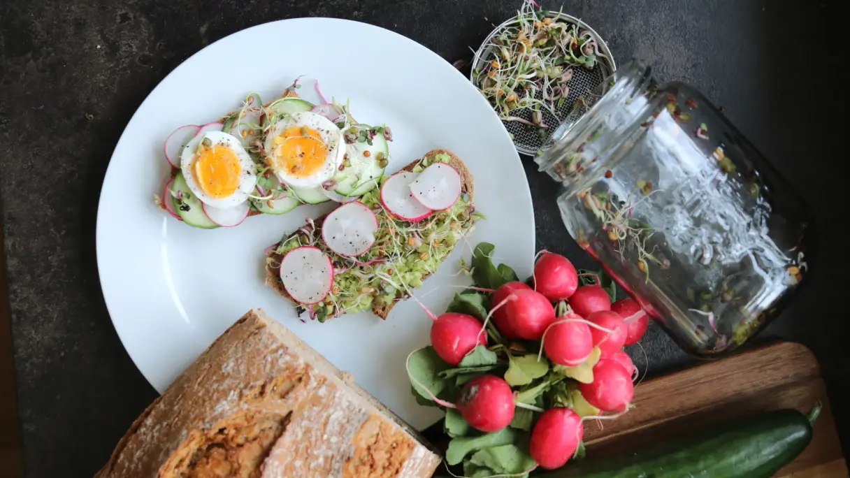 Sprossen auf Brot mit verschiedenem Gemüse angerichtet.