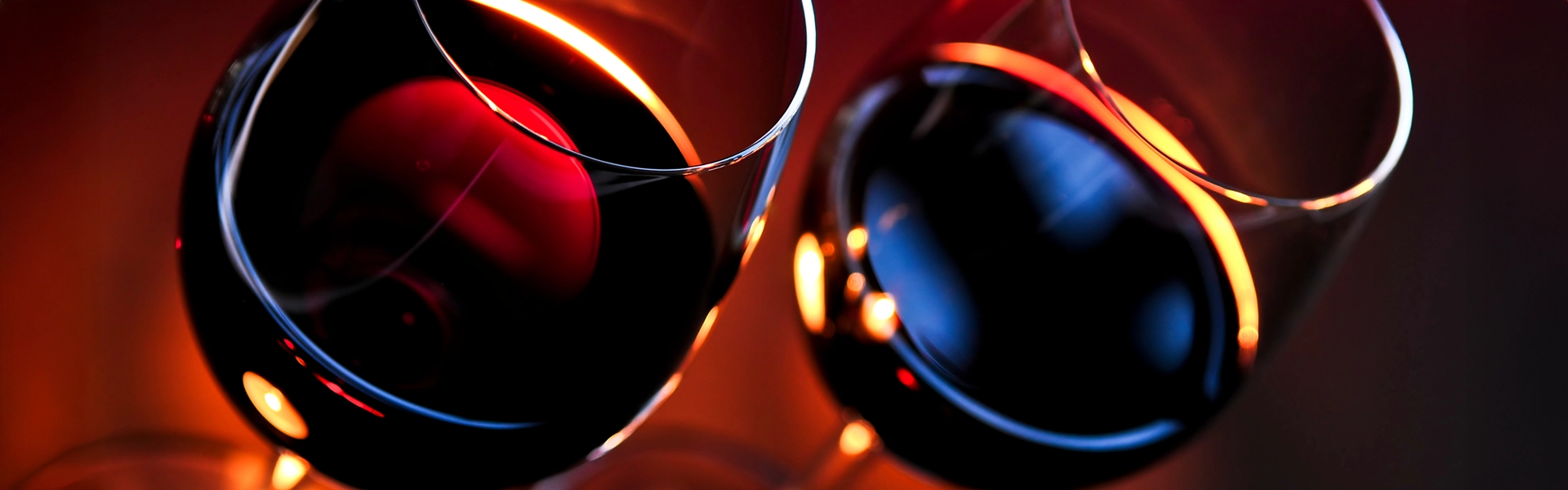 Wie beeinflusst die Lichtfarbe den Geschmack von Wein? Zwei Rotweingläser in rotem Umgebungslicht.