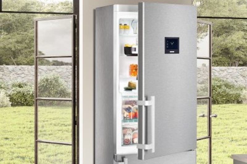 Half-opened freestanding CBNPes fridge-freezer in a kitchen