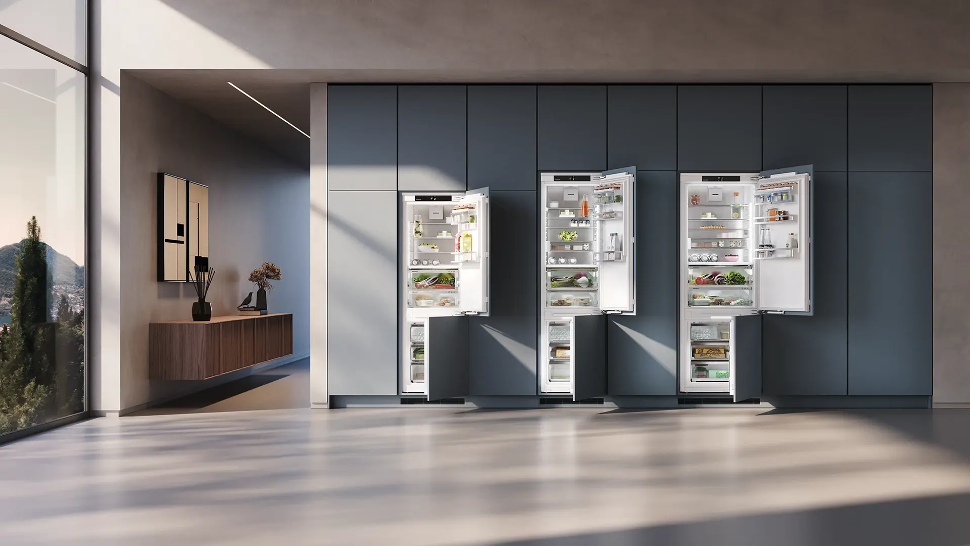 Integrated appliances: regular, XL and XXL size comparison Three integrated appliances shown open in a modern kitchen: a regular-size fridge freezer, an XL fridge and an XXL fridge freezer set against blue-toned wall units.
