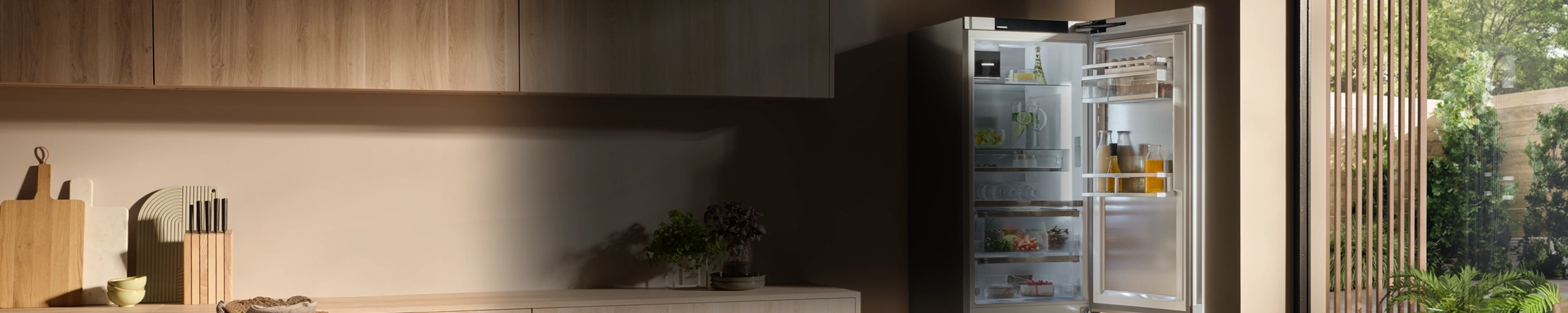 Geöffneter Kühlschrank in Küche mit Holzfronten. Abgedunkelter Bereich in der Mitte