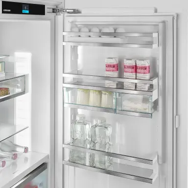 Kühlschranktür mit Flaschenhalter, auf dem zwei Wasserflaschen nebeneinander stehen.