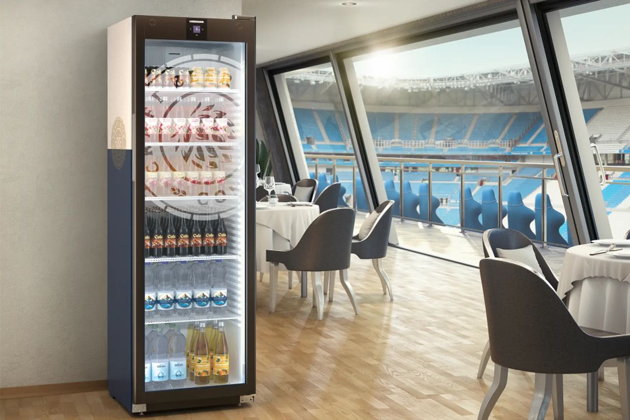 Liebherr Getränkekühlschrank mit individuellem Druck in Lounge mit Blick auf Fußballstadion.