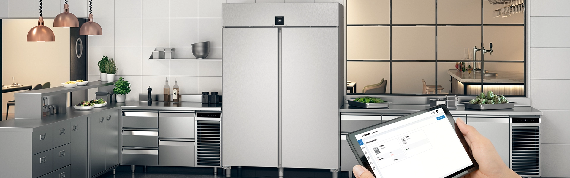 Commercial fridge in a gastronomy kitchen with worktops and a tablet displaying SmartMonitoring.