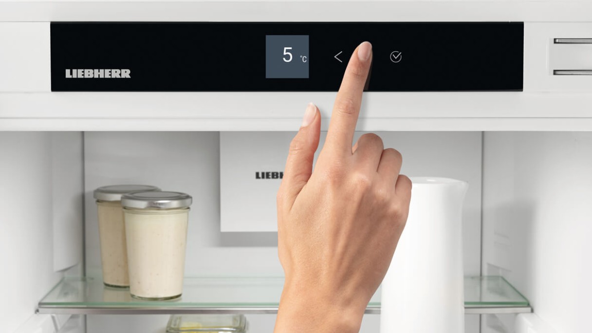 hand changing settings on appliance using touch display