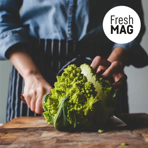 Person with apron cutting romanesco in the middle. FreshMAG logo in the top right corner