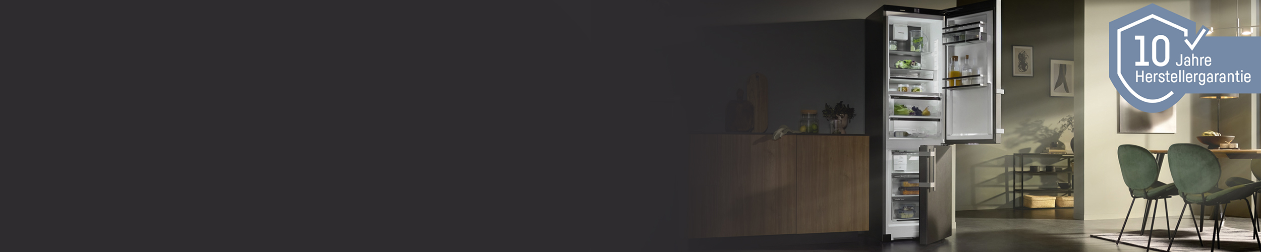 The CBNbsa575 fridge freezer stands elegantly in a modern kitchen, illuminated by soft sunrays filtering through the windows. The moody ambiance enhances the sleek design of the kitchen and dining area.