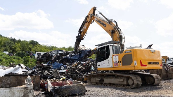 Operator using Liebherr excavator to safely dismantle aluminum wheels and stainless steel for recycling.