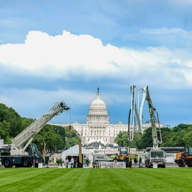 Image of  theLiebherr USA, Co. tent exhibit at Construction on the National Mall. Exhibits include an LRT 1090-2.1 rough terrain crane, 42 XXT concrete pump truck, L 546 wheel loader.