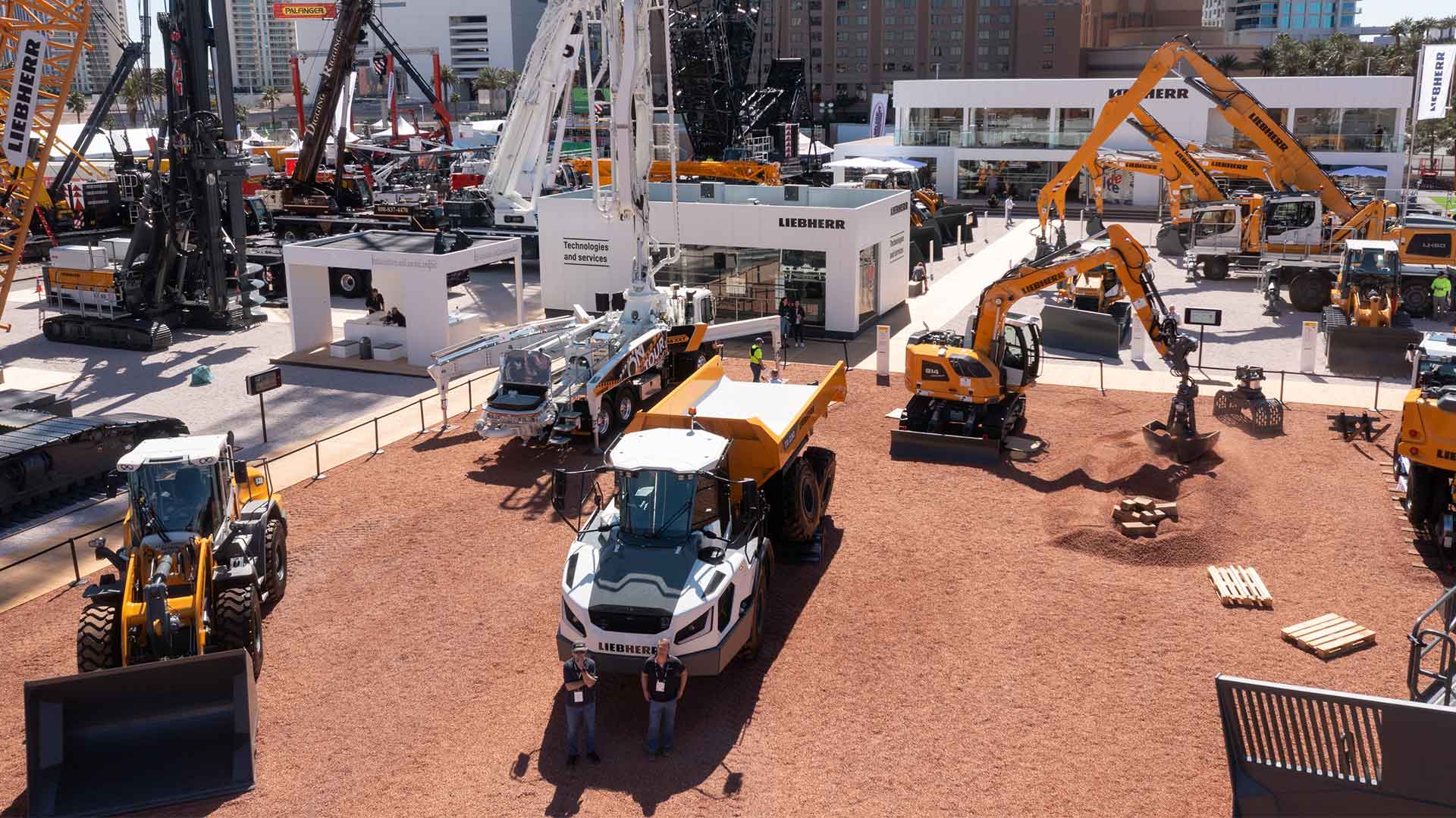 Aerial view of the Liebherr outdoor exhibit at CONEXPO 2023 showcasing heavy construction equipment including excavators, dump trucks, and cranes in Las Vegas.