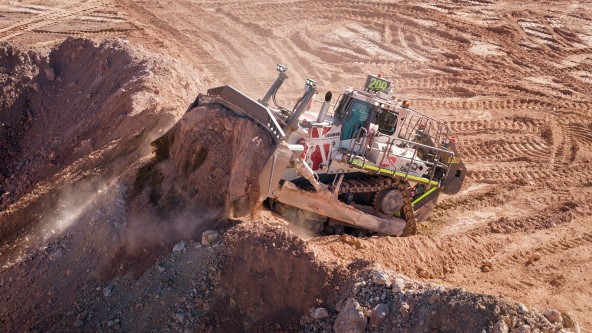 Liebherr PR 776 mining dozer at an open-pit mine Liebherr PR 776 mining dozer positioned on rugged terrain with its large blade facing forward.