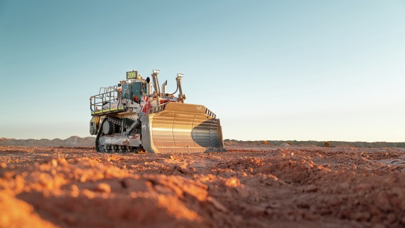 Liebherr PR 776 moving earth at a mine site Front view of a Liebherr PR 776 mining dozer pushing rocky material across an active mine site.