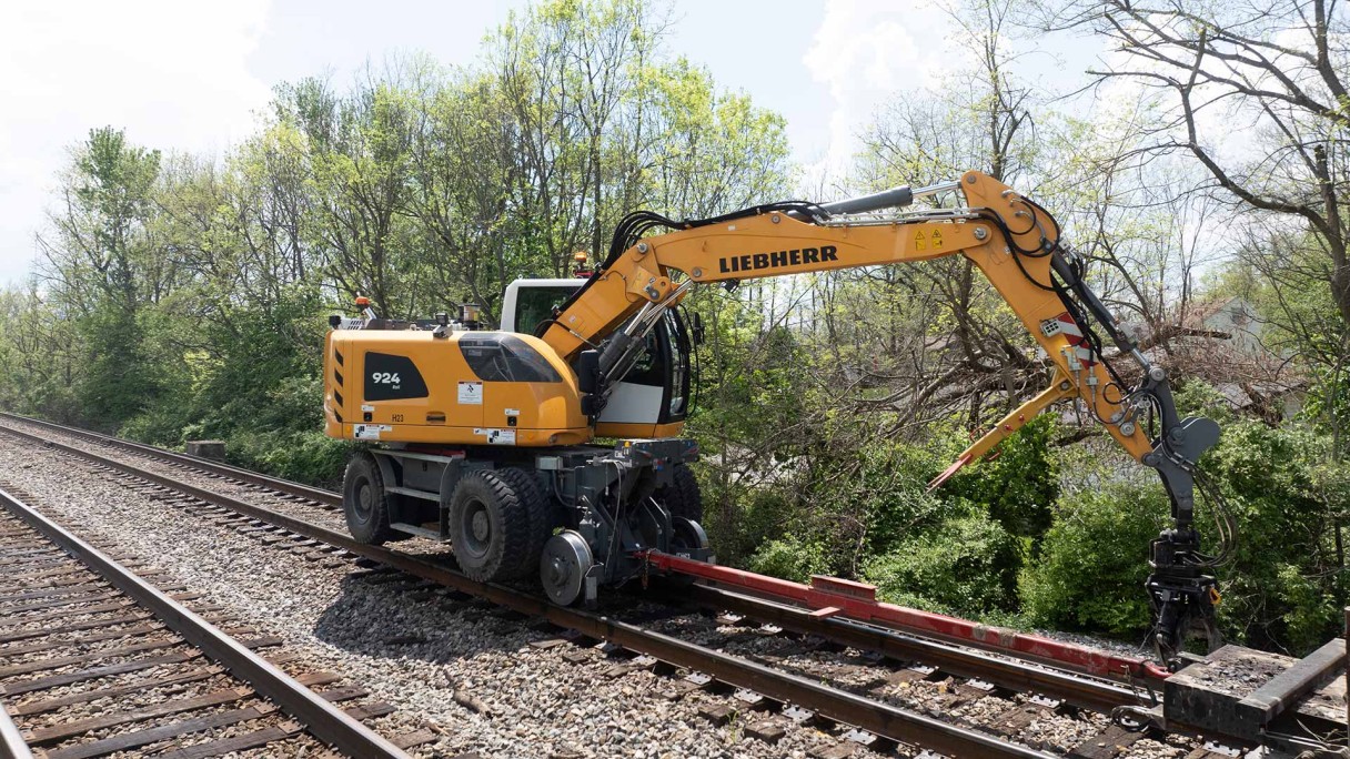 Image of Omaha Track, Inc. using the Liebherr A 924 rail excavator to perform railroad infrastructure  reclamation, abandoned track removal, new construction, track expansion, track maintenance, track inspections, and track repair on the Norfolk Southern railroad line.