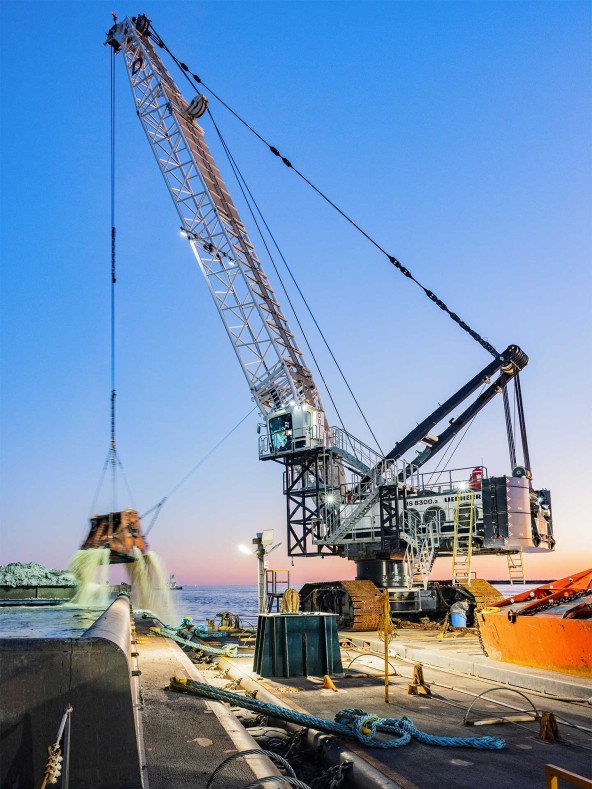 Dutra  Group and Matthews Brothers, Inc. operate the HS 8300 duty cycle crawler crane in Port Arthur, Tx in the Gulf of Mexico at sunset.